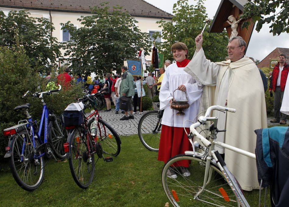 Pater Josef Gehrer segnete die Fahrräder der zahlreichen wetterfesten Teilnehmer, die zum 25. Unterallgäuer Radlertag nach Baumgärtle gekommen waren. Foto: Stefanie Dodel/Landratsamt Unterallgäu