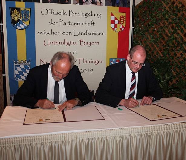 Hans-Joachim Weirather, Landrat des Landkreises Unterallgäu (im Bild links), und Matthias Jendricke, Landrat des Landkreises Nordhausen, unterzeichnen die Partnerschaftsurkunden. Fotos: Eva Büchele/Landratsamt Unterallgäu