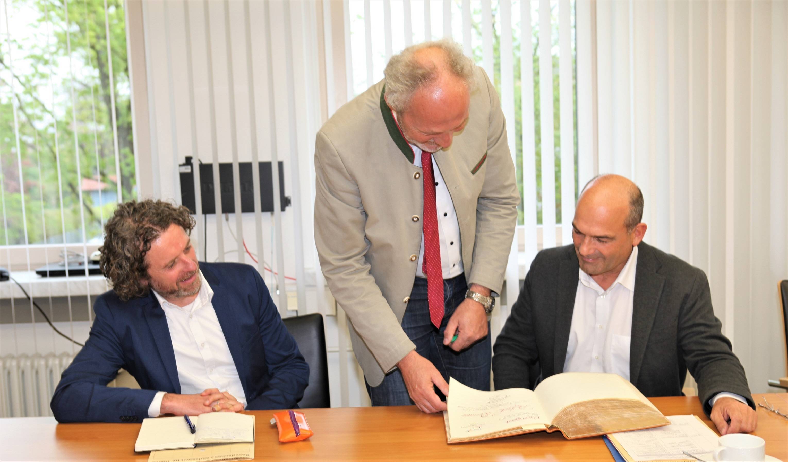 Dr. Markus Schick, Präsident des Bayerischen Landesamts für Pflege (im Bild rechts),  trug sich ins Gästebuch des Landkreises Unterallgäu ein. Bei seinem Besuch begleitete ihn Rüdiger Erling, Leiter des pflegefachlichen Teams (links). Landrat Hans-Joachim Weirather (Bildmitte) hieß die Gäste willkommen. Fotos: Eva Büchele/Landratsamt Unterallgäu