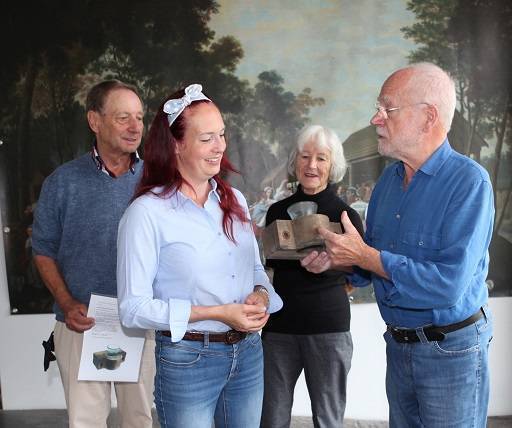 Birgit und Dieter Schaich (rechts im Bild) überreichen zusammen mit Kreisheimatpfleger Peter Hartmann (links) der Leiterin des Turmuhrenmuseums Veronika Vogt eine Glockenseilbuchse aus Glas. Foto: Eva Büchele/Landratsamt Unterallgäu