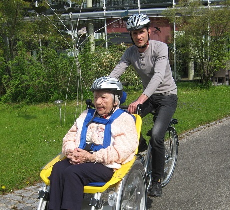 Pflegedienstleiter Robert Hoffmann dreht eine Runde mit Maria Jäger. Foto: Kreis-Seniorenwohnheim