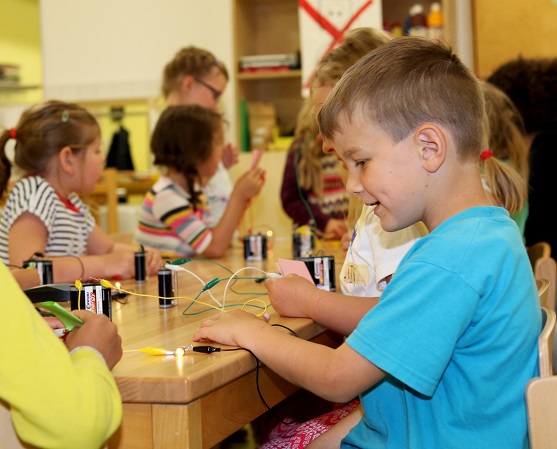 Kilian freut sich. Sein Lämpchen leuchtet bereits. Bei der mobilen Forscherzeit in der Kindertagesstätte in Pfaffenhausen können die Kinder selbst experimentieren. Foto: Eva Büchele / Landratsamt Unterallgäu