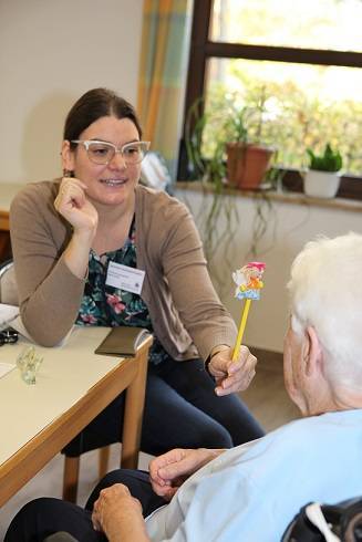 Mit dieser kleinen, bunten Fee testet Alexandra Schüssler-Englert vom Blindeninstitut Würzburg, wie gut die Bewohnerin des Kreis-Seniorenwohnheims St. Martin bewegte Gegenstände fokussiert. Foto: Eva Büchele / Landratsamt Unterallgäu 