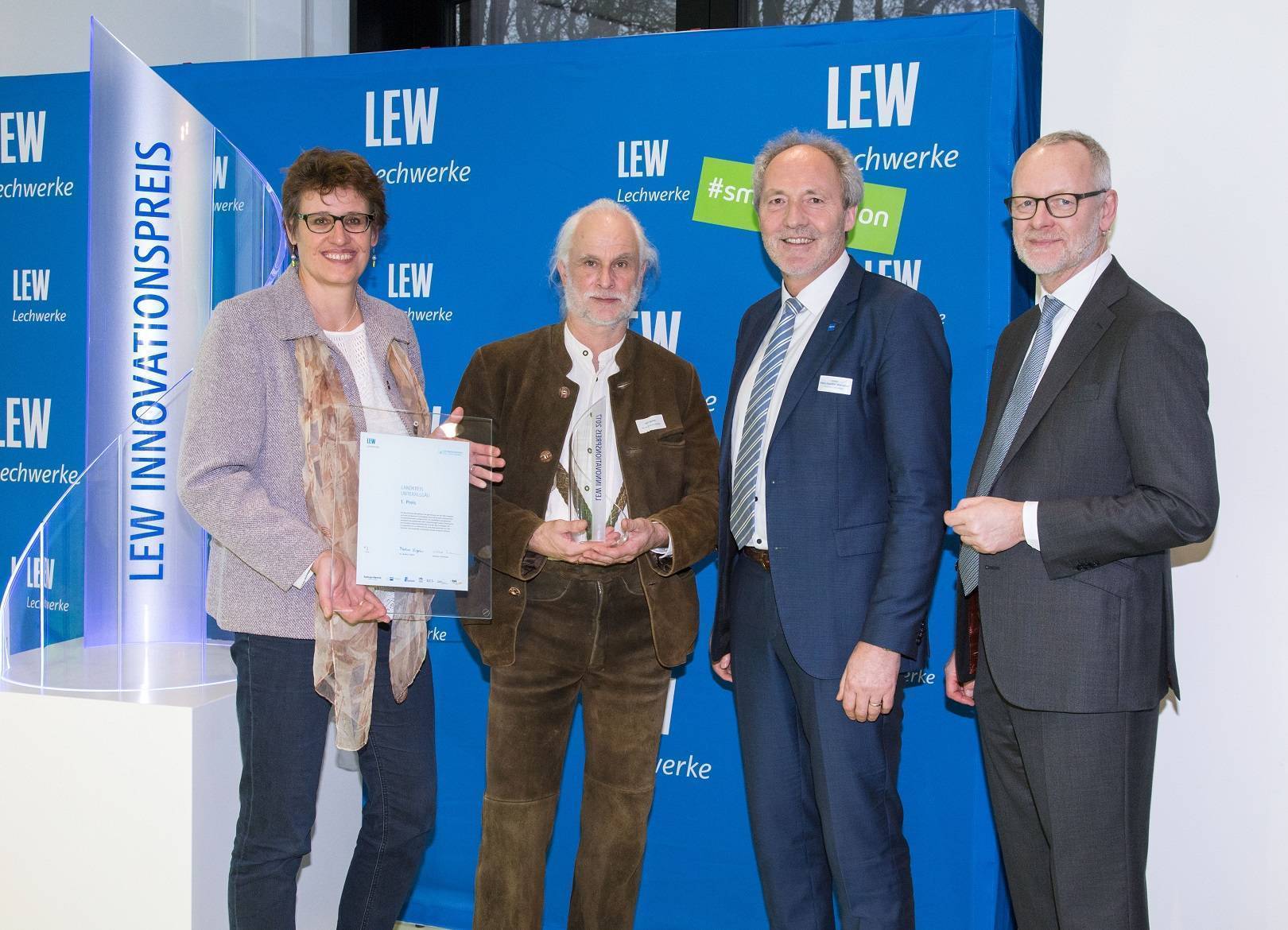 LEW-Vorstandsmitglied Dr. Markus Litpher (rechts) überreicht Pokal und Urkunde für den 1. Platz beim LEW Innovationspreis an Andrea Ruprecht, Klimaschutzmanagerin des Landkreises Unterallgäu, Karl Geller von der Berufsschule Mindelheim und Landrat Hans-Joachim Weirather. Foto: LEW/Bleier