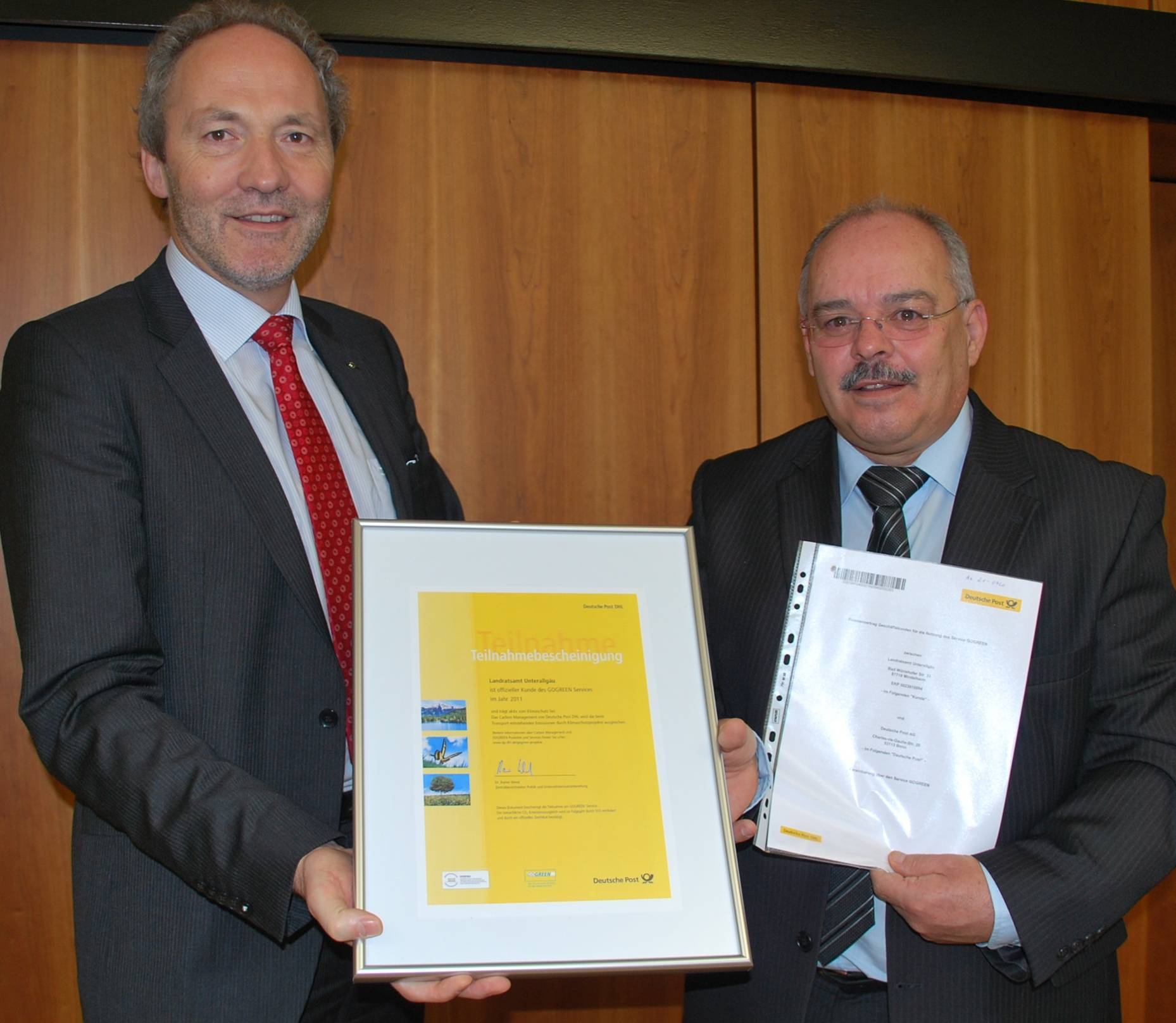 Das Landratsamt Unterallgäu verschickt seine Post seit Kurzem klimaneutral. Arnold Biberger von der Deutschen Post (rechts) überreicht Landrat Hans-Joachim Weirather ein entsprechendes Zertifikat.