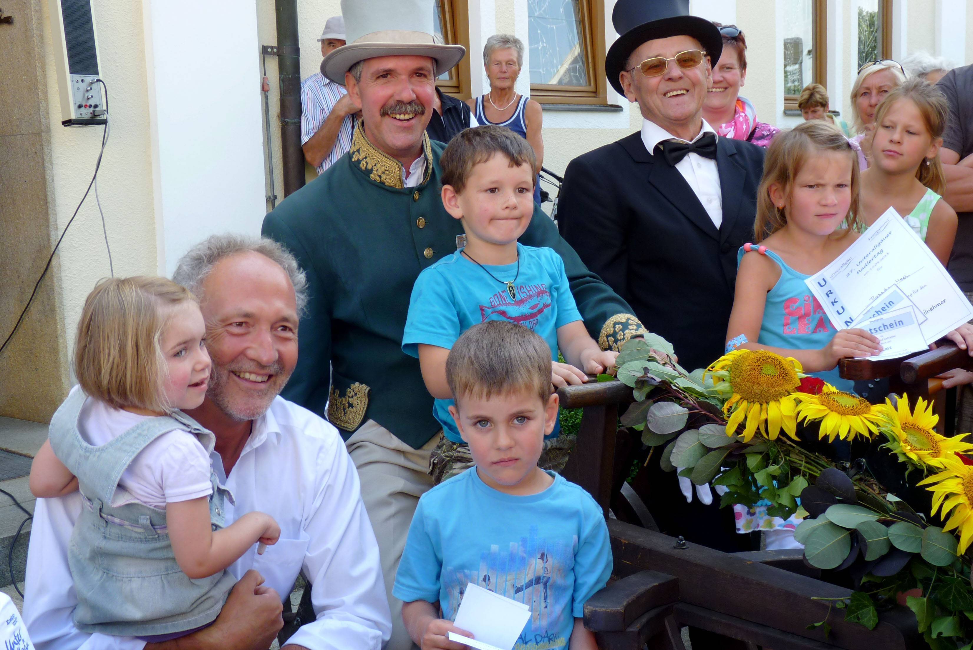 Die jüngsten Teilnehmer durften zur Siegerehrung auf die historischen Räder von Reinhold Stadler und Hubert Rogg steigen. Von links: Landrat Hans-Joachim Weirather mit Lotta Hartmann, Reinhold Stadler aus Markt Wald mit Ben Stegmann, davor Lorenz Walter