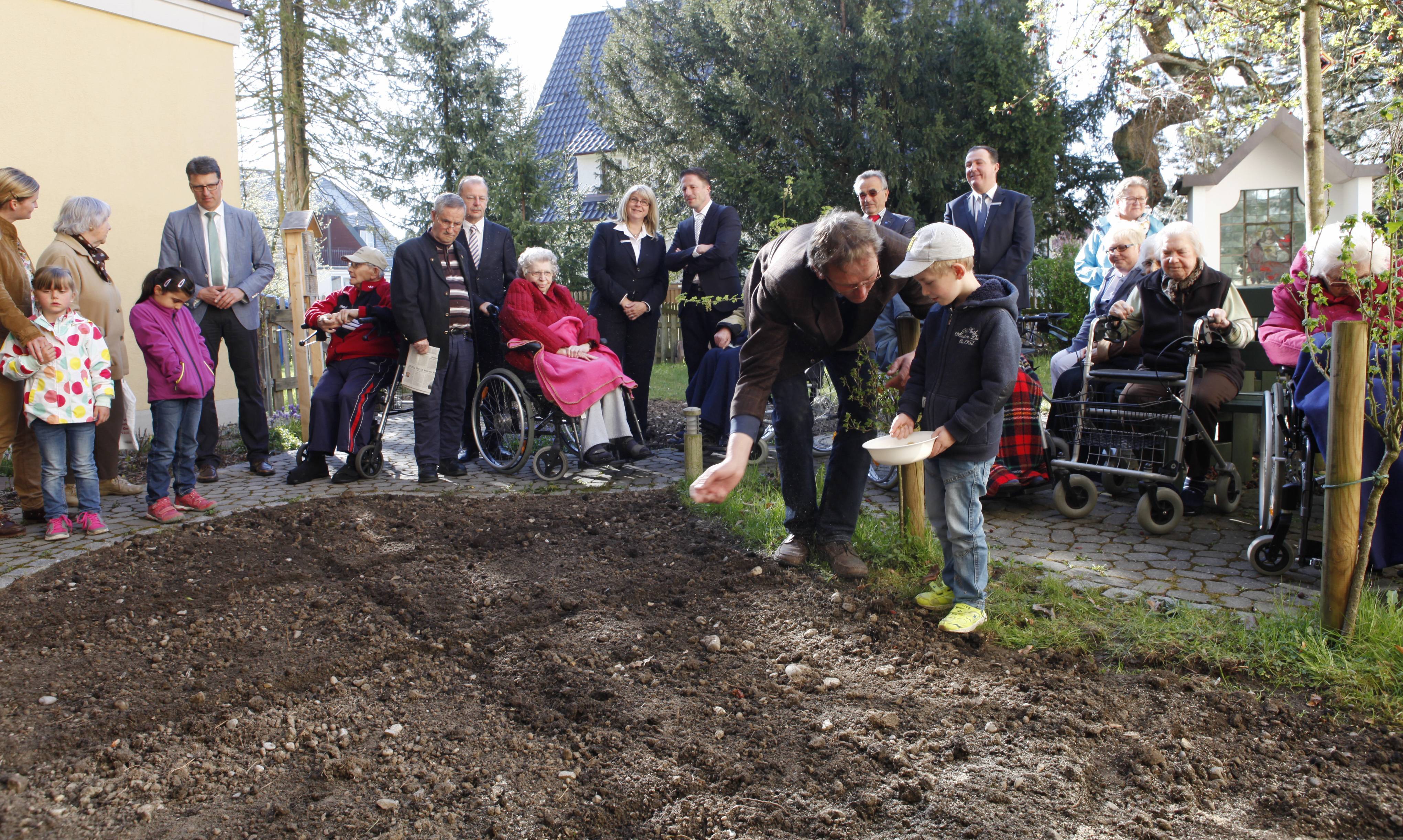 Vorschulkind Yannic säte zusammen mit Kreisfachberater Markus Orf eine kleine Fläche im Garten des Kreis-Seniorenwohnheims St. Andreas Babenhausen an. Foto: Stefanie Vögele/Landratsamt