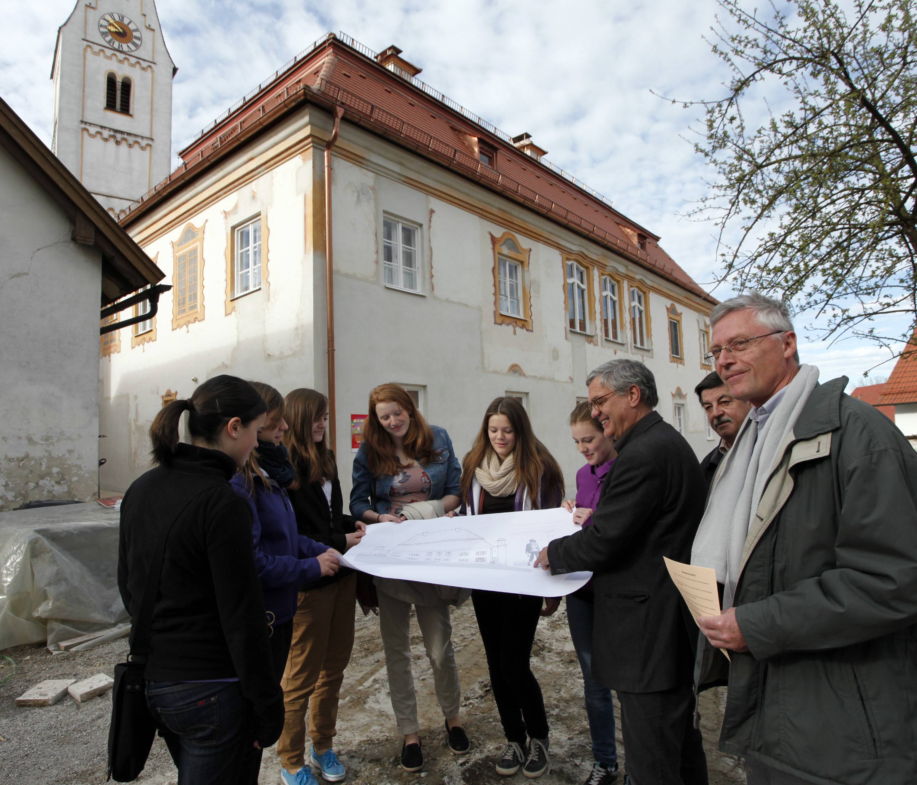 Kreisbaumeister Alfons Blachowiak (rechts) und Kreisheimatpfleger und Architekt Peter Kern (Zweiter von rechts) stellten Schülerinnen des Maristenkollegs vor Ort am denkmalgeschützten Pfarrhof in Zaisertshofen die Arbeit von Architekten vor. Kirchenpfle